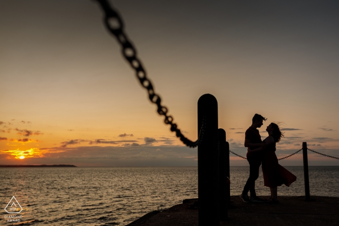 Photo by: <a href="https://www.wpja.com/photos/diamond-award-top-wedding-engagement-photographer/2551570">Catherine Hill - Canterbury Kent Engagement Portrait from Whitstable Harbour, Kent, UK | The couple embrase at the end of the pier at sunset