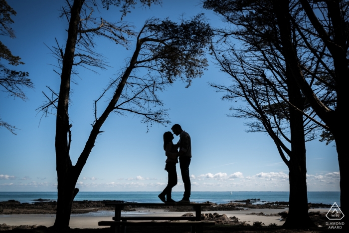 Photographie de fiançailles pour l'île d'Yeu, France - L'image contient: plage, sable, arbres, silhouette, couple, fiancés