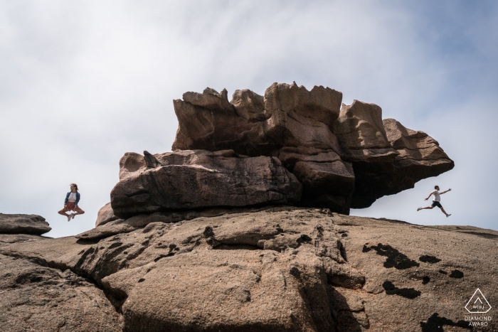 Fotógrafo de compromiso para Tregastel, Francia - Retrato previo a la boda con una pareja saltando en las rocas