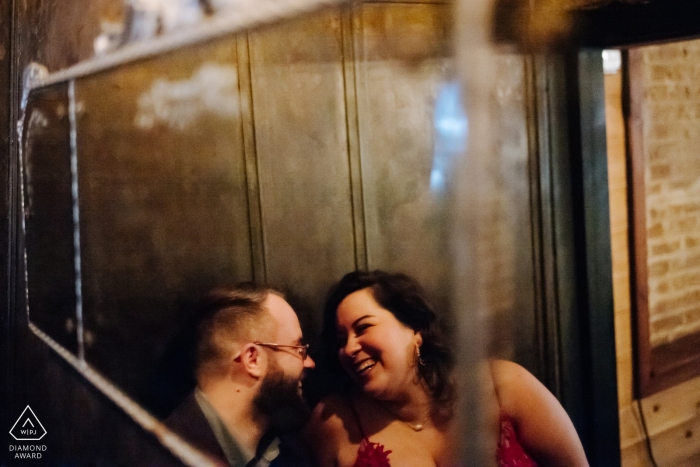 Engagement Photos of a Texas Couple snuggling and laughing in mirror reflection at Dean's Downtown cozy bar in Houston Engagement Photos from Texas | Couple snuggle and laugh in mirror reflection at Dean's Downtown cozy bar in Houston