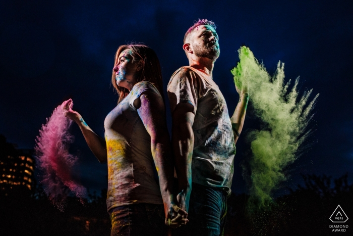 Photographe d'engagement pour le Maryland à la maison du client avec de la poudre holi et un éclairage dramatique