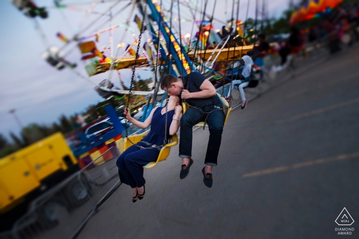 Photos de fiançailles de la foire locale à Edmonton - Un couple chevauche les balançoires à la foire