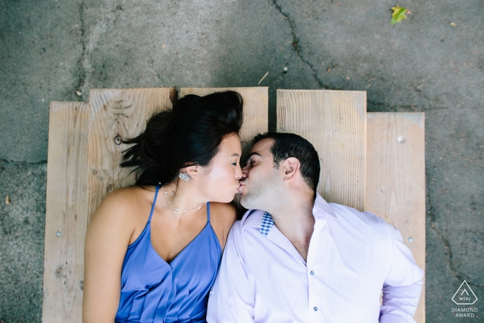 Fotos de compromiso de Seattle, WA - Mirando hacia abajo a una pareja besándose en una mesa de picnic