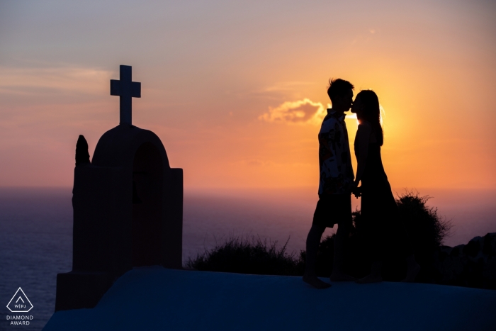 Fotos de noivado em Santorini - A imagem contém: pôr do sol, igreja, cruz, silhueta