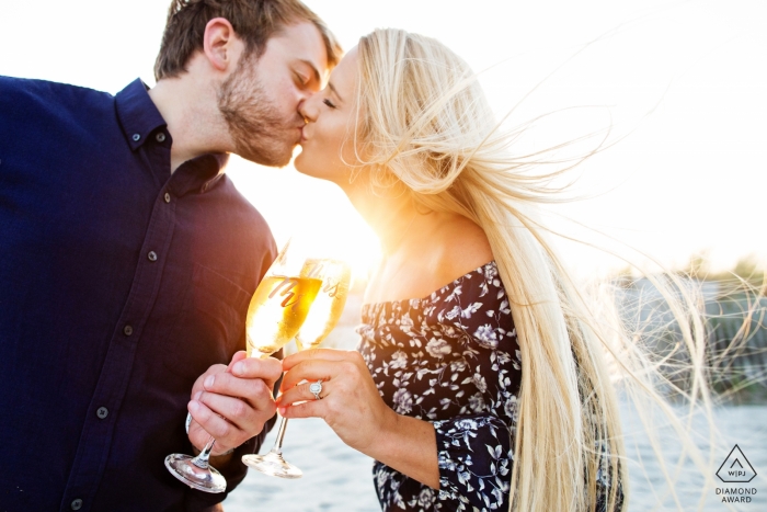 Fotógrafo de noivado em Avalon, New Jersey Beach - A imagem contém: casal, beijo, praia, copos de vinho, torradas, noivo