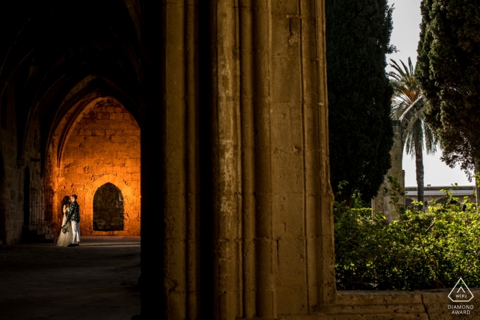 Photo by: <a href="https://www.wpja.com/photos/diamond-award-top-wedding-engagement-photographer/2551891">Orçun Yalçın - Ankara Ankara Engagement Portrait from Bellapais Monastery, Kyrenia, Cyprus - Couple is kissing in front of a highlighted wall