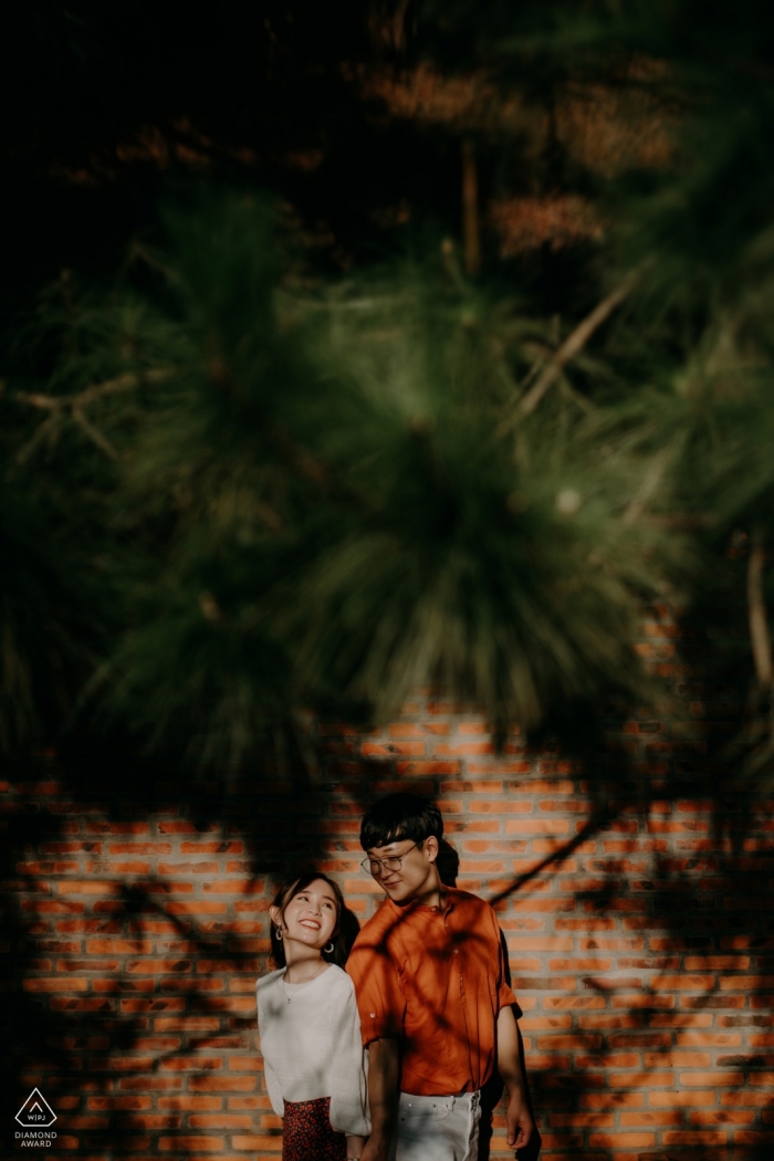 Engagement Photographer for Dalat, Vietnam - Image contains: couple, shadows, trees, pine, wood