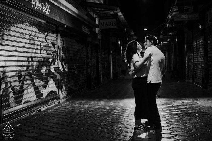 Foto: <a href="https://www.wpja.com/photos/diamond-award-top-wedding-engagement-photographer/2551958"> Orçun Yalçın - Ankara Ankara Verlobungsfotos aus Athen, Griechenland - Ein Paar, das auf einer engen Straße voller Graffitis steht, umarmt sich und lacht