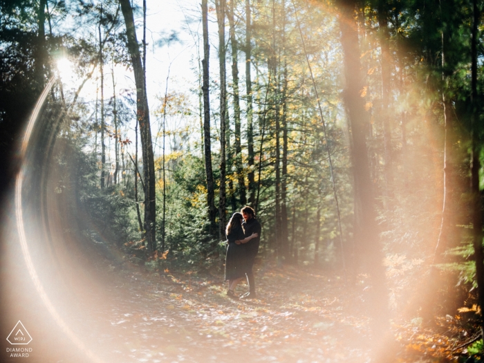 Saco, ME Portraits de fiançailles sur un sentier dans les arbres - Photo avec une fusée éclairante à l'automne