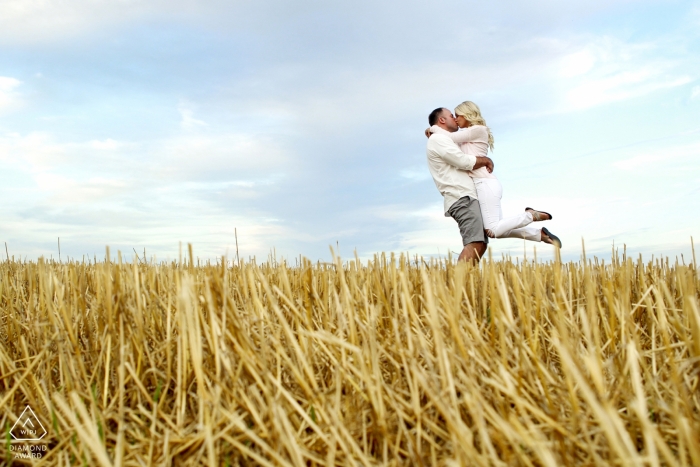 Elburn, IL | The engaged couple embrace in the middle of a harvested wheat field. 