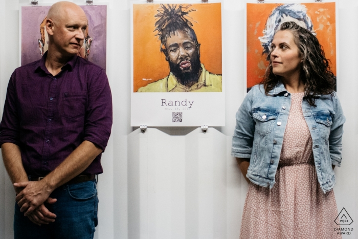 Pareja comprometida jugando con retratos en una exposición en Filadelfia