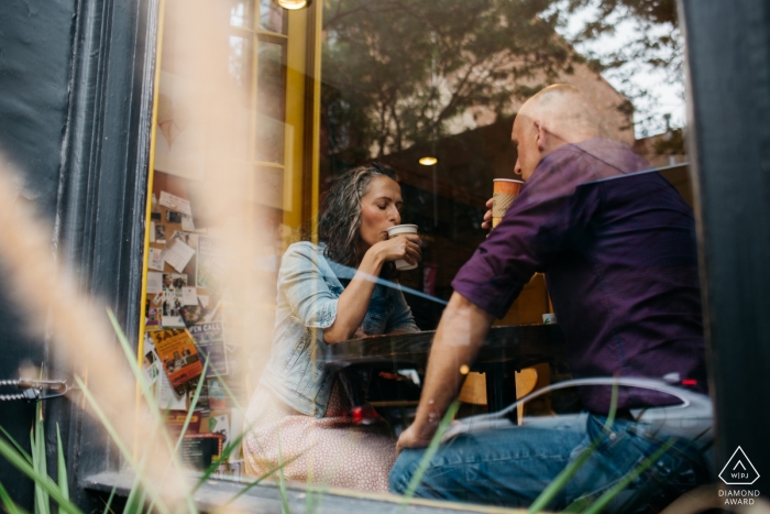 Pareja está tomando café juntos en Cherry Street en Filadelfia durante su sesión de retratos de compromiso