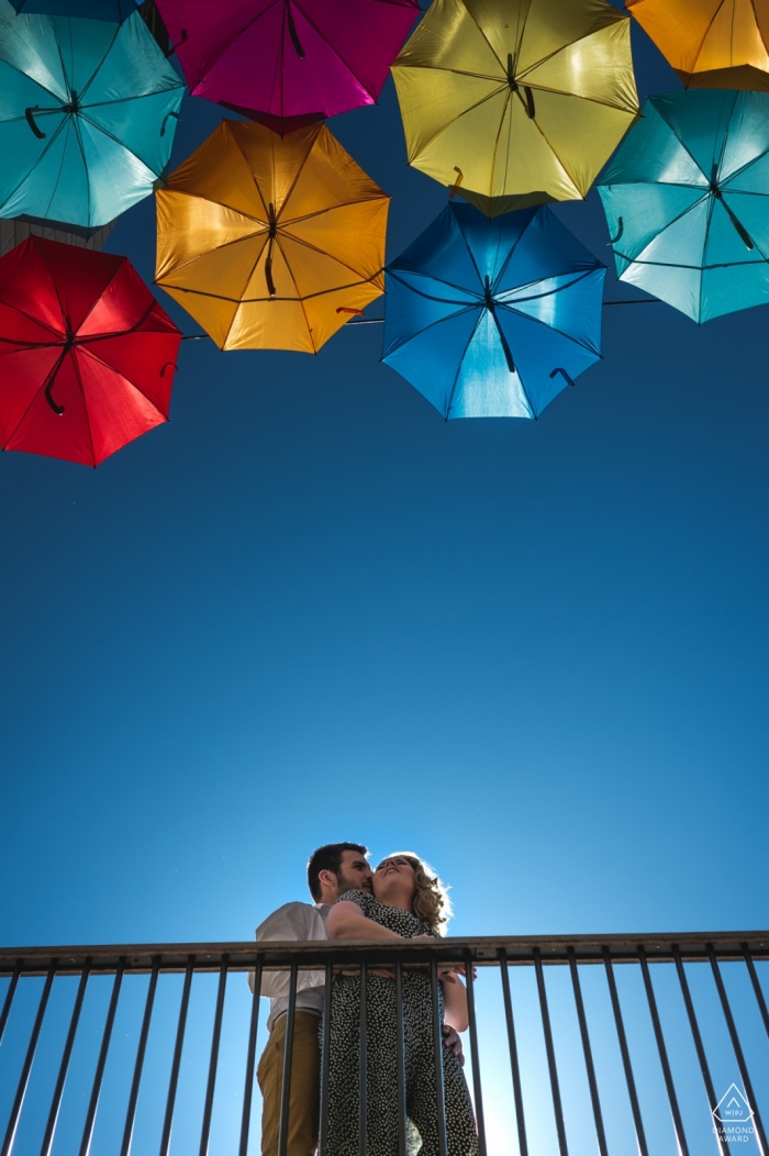 Bunte Regenschirme in Bordeaux, Frankreich, auf diesem Verlobungsporträt eines Paares