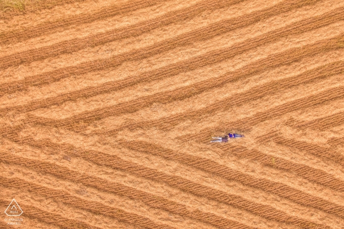 Photo by: <a href="https://www.wpja.com/photos/diamond-award-top-wedding-engagement-photographer/2552695">Simona Cancelli - Siracusa Siracusa Siracusa engagement shoot - Drone photography of couple lying in field