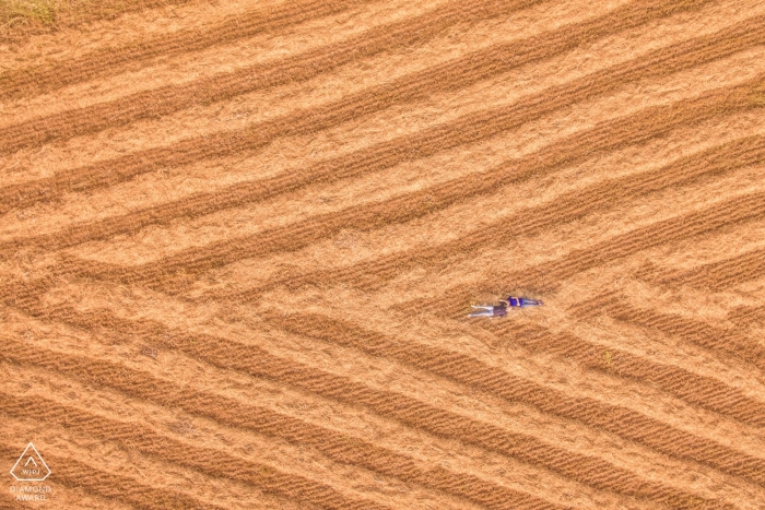 Sesión de compromiso de Siracusa: fotografía con drones de una pareja acostada en el campo