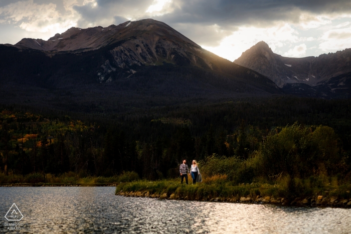 Foto: <a href="https://www.wpja.com/photos/diamond-award-top-wedding-engagement-photographer/2554027"> Trent Gillespie - Silverthorne Colorado Verlobungsfotografie in Silverthorne, CO - Gehen Sie neben einem Teich entlang, während die Sonne über der Gore-Bergkette untergeht.