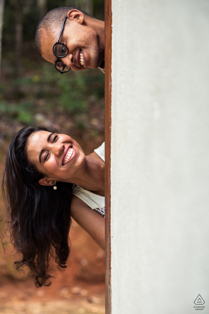 Vicosa Brazil Engagement Photographe: Couple avec leurs visages sortant du mur