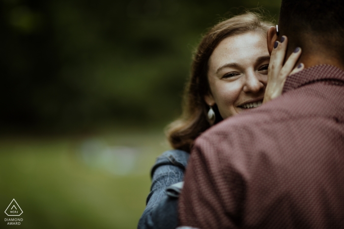 Photo by: <a href="https://www.wpja.com/photos/diamond-award-top-wedding-engagement-photographer/2554660">Kevin Wright - Attleboro Massachusetts Boston, MA Engagement Shoot - She peeks over his shoulder during a hug at their Jamaica Pond session