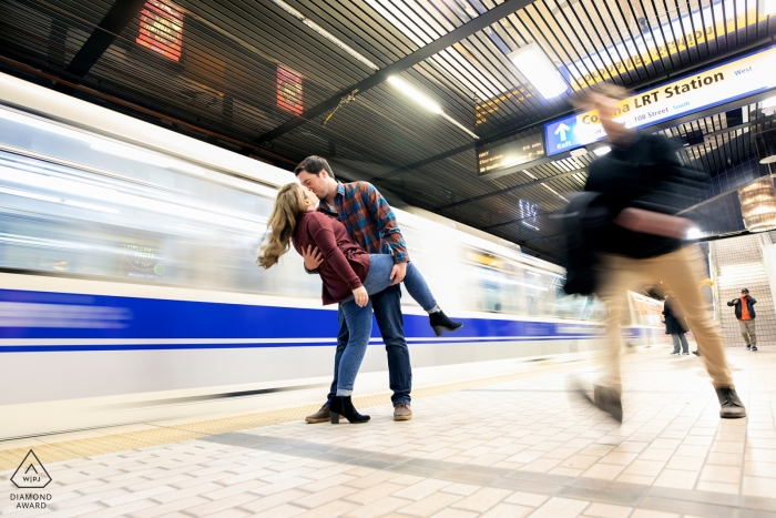 Edmonton, Alberta Pareja se besa mientras pasa el tren durante la sesión de fotos del retrato previo a la boda