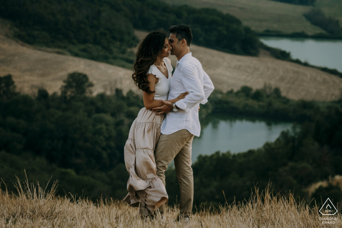 Toscana, Crete senesi - una coppia abbracciata dal vento durante una sessione fotografica pre-matrimonio all'aperto