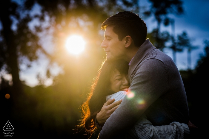 Foto: <a href="https://www.wpja.com/photos/diamond-award-top-wedding-engagement-photographer/2555146"> Allison Williams - Chicago, Illinois Humboldt Park, Chicago IL Verlobungsfotograf | Ein paar Umarmungen in einem Lichtstrahl bei Sonnenuntergang