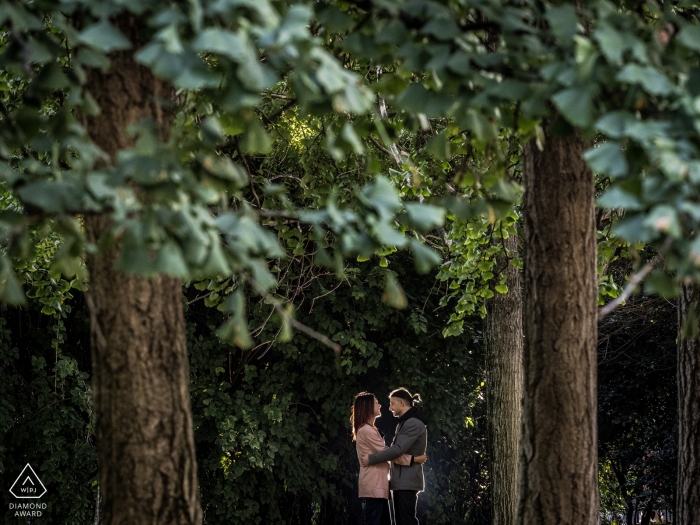 Milano, Italia foto di fidanzamento di una coppia tra gli alberi ad alto fusto