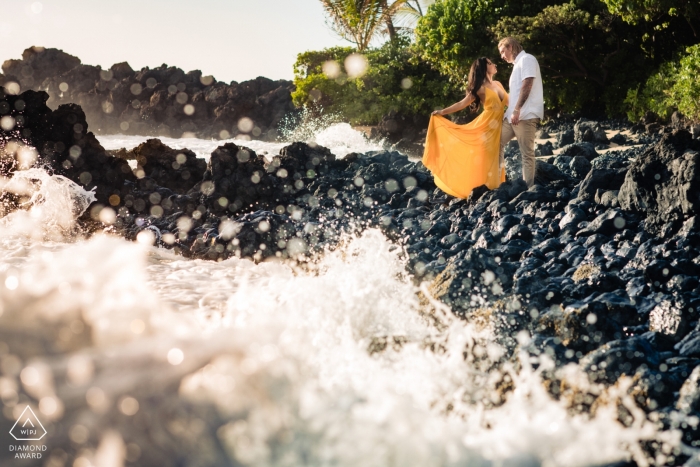 Fotógrafo de compromiso de Hawái: salpicaduras de olas con pareja en las rocas en Makena, Maui