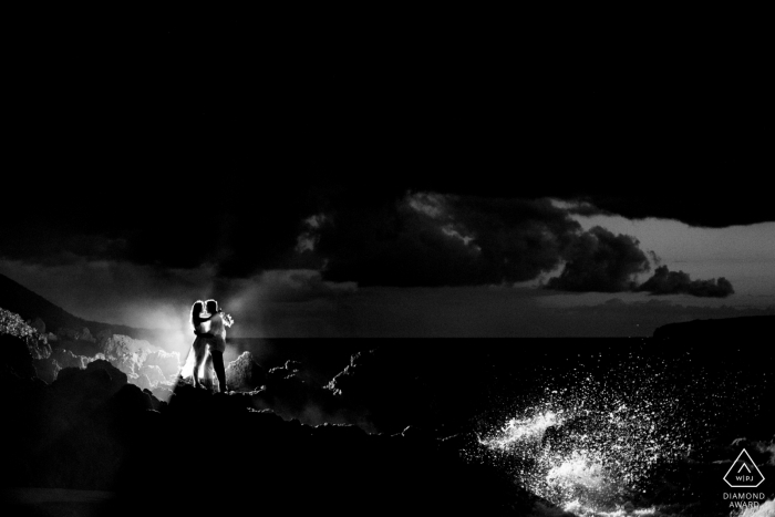 Wailea, Maui, Hawaii | Couple noir et blanc avec éclaboussures de vagues après la tombée de la nuit