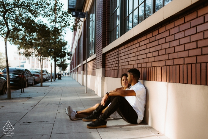 Verlobungsporträts eines Paares, das auf den Straßen von Downtown LA sitzt