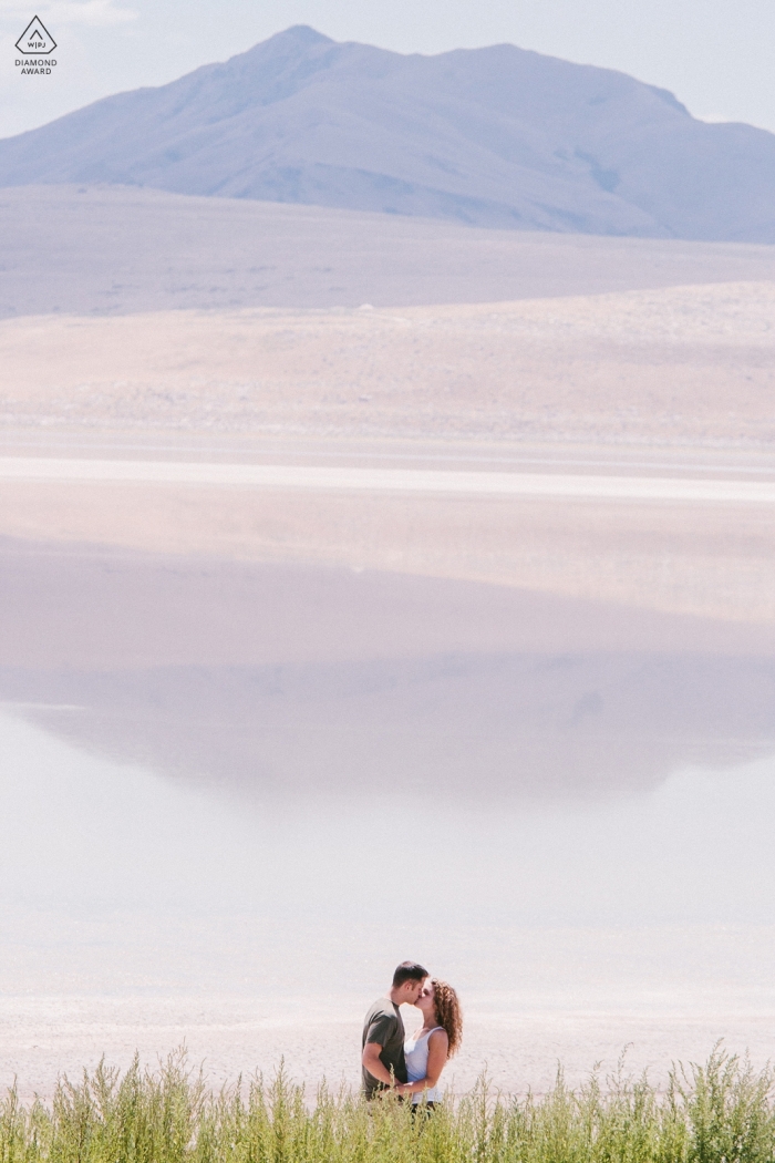 Salt Lake City, Utah Couple kissing next to lake during engagement portrait session