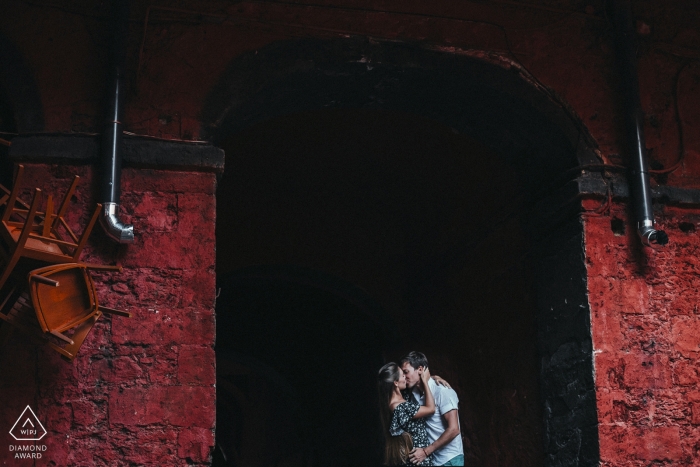 Photo by: <a href="https://www.wpja.com/photos/diamond-award-top-wedding-engagement-photographer/2560058">Emre Nesli - İstanbul Istanbul Odessa Ukraine Engagement Portrait — a couple kissing in front of a red bridge