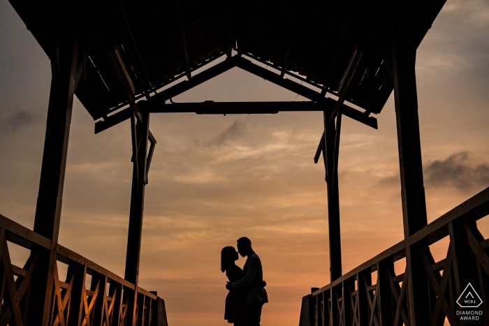 Photo by: <a href="https://www.wpja.com/photos/diamond-award-top-wedding-engagement-photographer/2560100">Maik Dobiey - Santiago de Surco Lima Barranco, Lima, Peru Portrait Session — Couple in the middle of an old wooden bridge in front of sunset