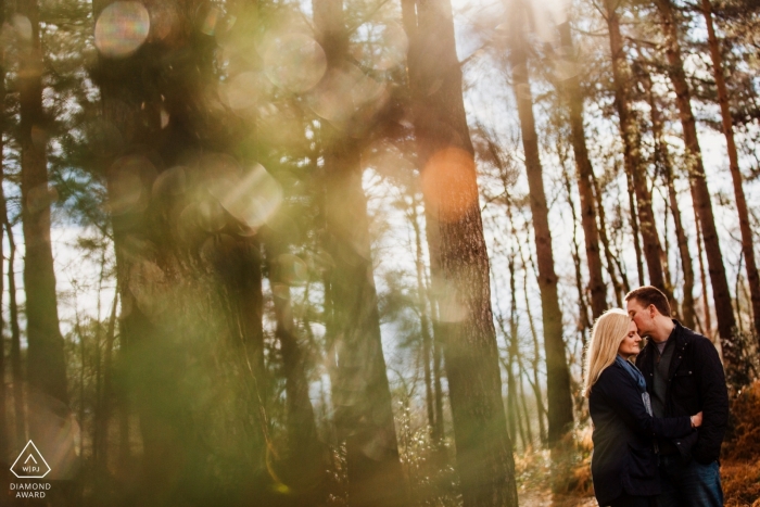 Heath, West Sussex Woodland ama o retrato de um casal nas árvores e na luz do sol.