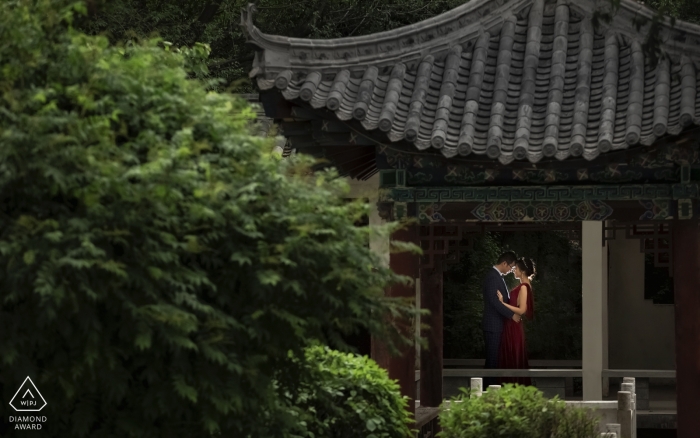 Photo: <a href="https://www.wpja.com/photos/diamond-award-top-wedding-engagement-photographer/2562411"> Binbin Wong - Xining City Un couple nouvellement fiancé s'embrassent dans le pavillon de la cour de l'hôtel Xining, Qinghai