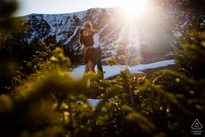 Pareja comprometida Tomando el último sol durante su sesión de compromiso en Loveland Pass.