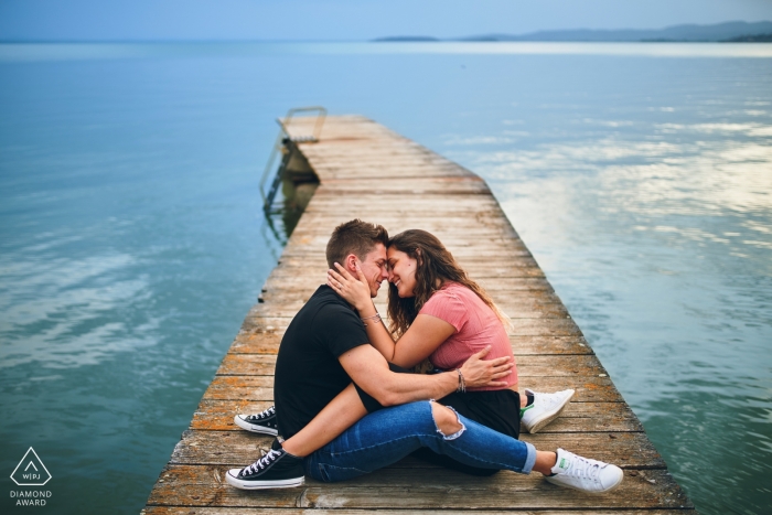 Liebesporträtsitzung am Trasimenischen See – Paar auf dem Dock am Wasser.