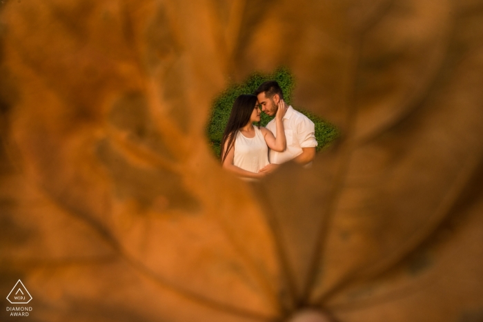 Photo by: <a href="https://www.wpja.com/photos/diamond-award-top-wedding-engagement-photographer/2563160">Dante Ceccon - Lima Lima Miraflores Lima E Session with a Couple in the grass - Shot through a Leaf
