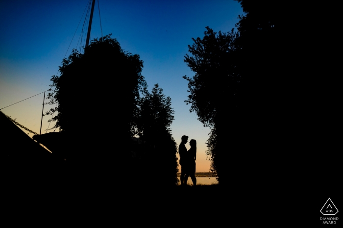 Sesión de retratos previos a la boda de Baden-Wurttemberg - Pareja de silueta con árboles y cielo azul.