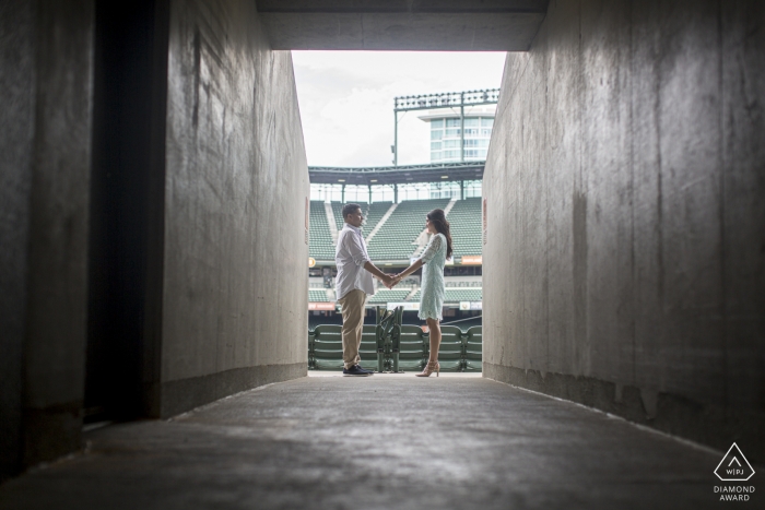 Camden Yard, Oriole Park, Baltimore, MD showing the Couple is becoming part of the geometry during their Camden Yard engagement session, a lifelong dream for them Camden Yard, Oriole Park, Baltimore, MD - Couple is becoming part of the geometry during their Camden Yard engagement session, a lifelong dream for them.