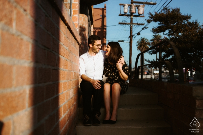 Downtown Los Angeles, CA Casal sentado nos degraus durante a sessão de noivado da tarde.