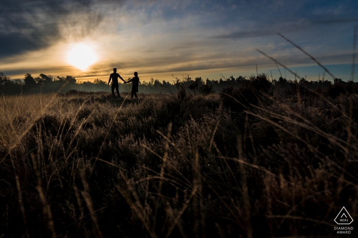 Photo: <a href="https://www.wpja.com/photos/diamond-award-top-wedding-engagement-photographer/2565280"> Caroline Elenbaas - Heijningen Noord Brabant Rucphense Heide, Rucphen Pre Portraits de mariage - Un couple marchant dans la lande, à la lumière du matin, avec de jolies couleurs.