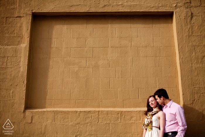 Brooklyn, NY Pareja frente a la pared durante una sesión de compromiso por la tarde.