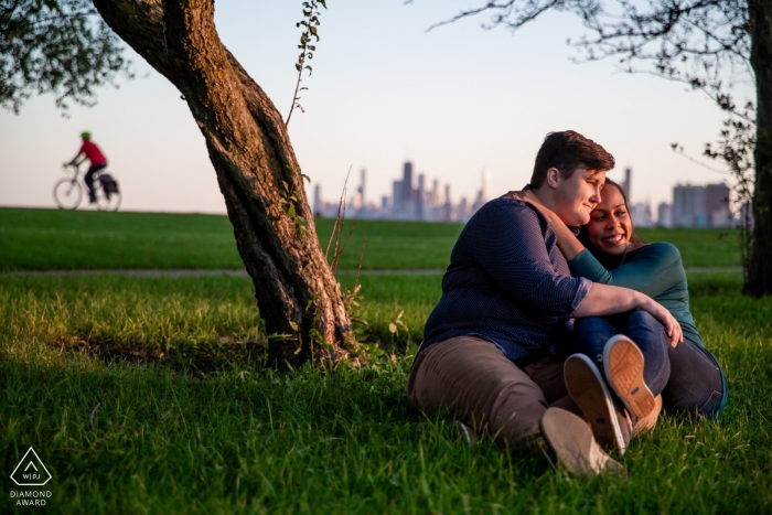 Photo by: <a href="https://www.wpja.com/photos/diamond-award-top-wedding-engagement-photographer/2565527">Victoria Sprung - Chicago Illinois Montrose Beach, Chicago Portraits - Engaged couple with bicyclist in background