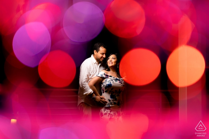Courtyard by Marriott, Isla Verde PR Engagement Picture Session with Champagne Glasses to create bokeh that frames the couple Courtyard by Marriott, Isla Verde PR Engagement Picture Session - Portrait contains: Champagne Glasses to create bokeh that frames the couple