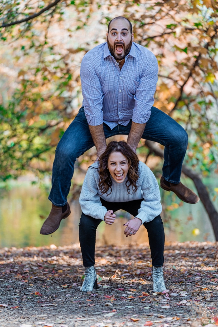 Sessão de fotos de noivado em Londres, Reino Unido - A imagem contém: diversão, casal, salto, sapo, feliz, alegria