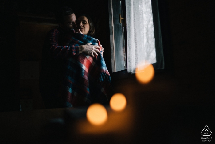 South Tyrol Engagement Photo Session - Porträt enthält: Bokeh, drinnen, Umarmung, Fenster, Licht