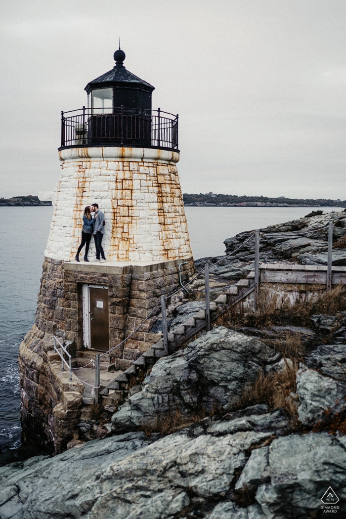 New England engagement portrait - Picture Session - Portrait contains: lighthouse, rocks, jetty, couple, water