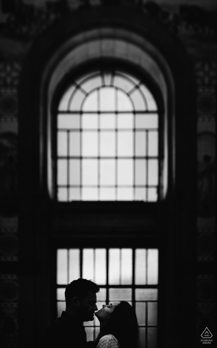 Photo by: <a href="https://www.wpja.com/photos/diamond-award-top-wedding-engagement-photographer/2567796">Daniel Monteiro - Porto Portugal Engagement Photography - Portrait contains: window, glass, stained, kiss, chin, vertical