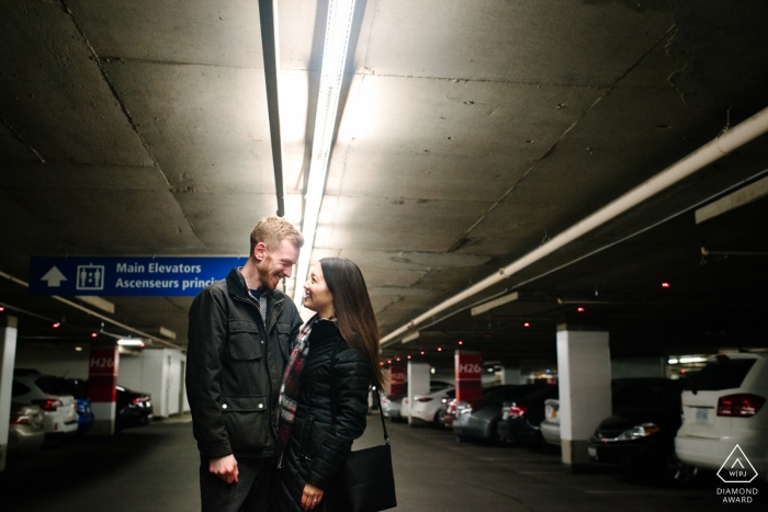 Ontario, Canada Couple Engagement Portrait - Image contains: pause in the parking lot, underground, garage, cars, lighting, concrete