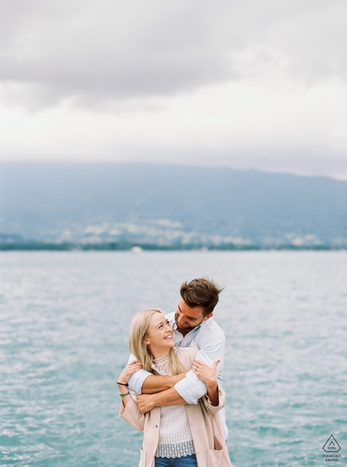 Photo by: <a href="https://www.wpja.com/photos/diamond-award-top-wedding-engagement-photographer/2568329">Sylvain Bouzat - Lyon Annecy Film photo of a engaged couple at the water.